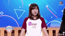 a girl is wearing a shirt that says bnk 48 on it