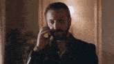 a man with a beard is talking on a cellphone
