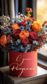 a bouquet of flowers in a red box that says ' cdnem рождения ' on it