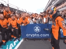 a group of people are holding a sign that says crypto.com