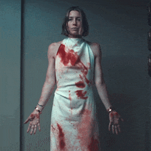 a woman in a bloody white dress is standing with her hands outstretched