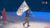 a person holding an olympic flag with the number 2 on the bottom