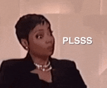 a woman is making a surprised face in front of a sign that says plsss