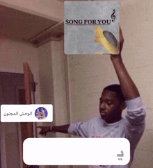 a man holding up a sign that says song for you