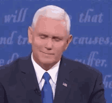mike pence is wearing a suit and tie and making a face .
