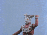 a monster with horns is standing in a field with trees and grass .