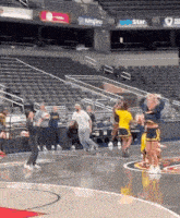 a group of cheerleaders are performing on a basketball court in an empty stadium
