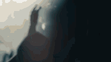 a blurred image of a person 's hand reaching out towards the sky