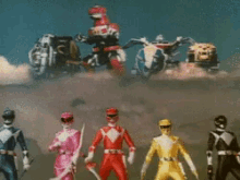 a group of power rangers holding swords in front of a robot