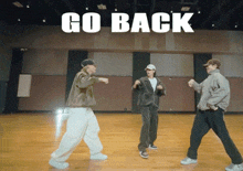 a group of people are dancing in a room with the words go back behind them