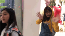 a girl wearing overalls and a hoodie with the word gerkung on the bottom