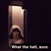 a person wearing a hooded jacket is standing in a dark room and says what the hell sure