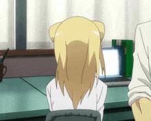 a girl sits at a desk with a laptop and a book that says ' chinese ' on the front