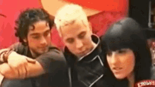 a group of young people are sitting next to each other on a red couch .