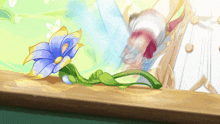 a blue and yellow flower with a green stem sits on a wooden table