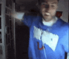 a blurry picture of a man wearing a blue shirt with the letter u on it .
