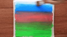 a person is using a brush to paint a picture of a landscape