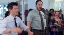 two men in ties are dancing in front of a crowd of people .