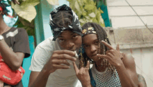 a man wearing a bandana is smoking a cigarette next to a woman wearing a supreme bag