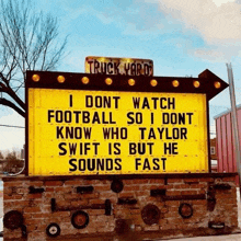a yellow sign says i dont watch football so i dont know who taylor swift is but he sounds