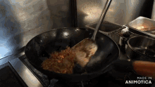 a wok is being stirred with a spatula and the words made in animatica are visible