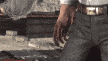 a man in a suit is kneeling down with his hands in his pockets