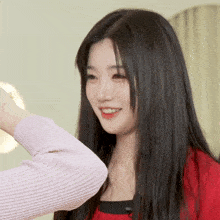 a woman in a pink sweater holds another woman 's arm and smiles