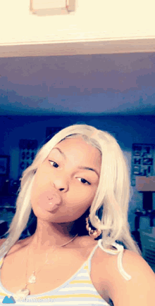 a woman is taking a selfie with a bubble in her mouth
