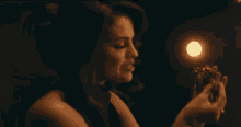 a woman in a dark room is holding a candle