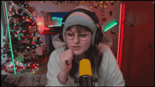 a woman wearing headphones and glasses is talking into a microphone