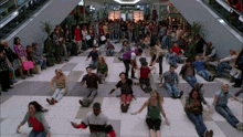 a large group of people laying on the floor in a mall