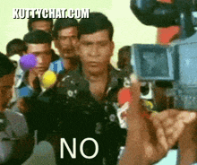 a man stands in front of a camera with the words no on his face