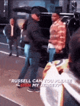 russell can you please sign my jersey ' is written on a person 's shirt
