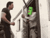 a man is holding a sword while another man holds a green box on his head .