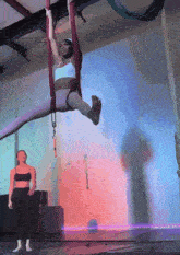 a woman is hanging upside down in a purple hammock