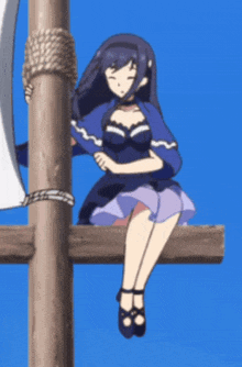 a girl in a blue dress is sitting on a pole