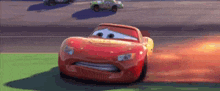 lightning mcqueen from the movie cars is driving down a race track .
