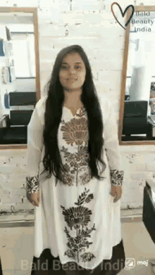 a woman with very long hair is standing in front of a mirror in a hair salon ..