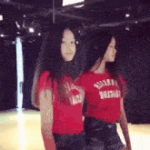 two girls are standing next to each other in front of a mirror wearing red shirts that say abercrombie and fitch