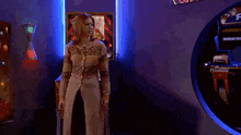 a woman is dancing in front of a pinball machine that says planet harmony