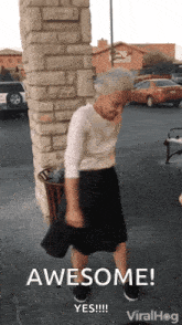 an elderly woman is standing in front of a brick wall and says awesome yes