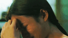 a woman is crying with her hand on her forehead .