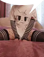 a person wearing a cat t-shirt and fishnet stockings is sitting on a bed