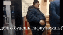 a man in a black jacket is standing next to a man in a blue jacket and a sign that says долго будешь
