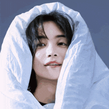 a close up of a person 's face with a white blanket over their head