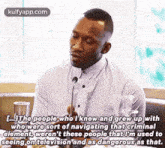 a man is talking into a microphone and saying `` the people who i knew and grew up