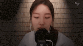 a woman wearing ear buds and a microphone with the word rang on the bottom