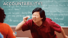 a man is sitting in front of a chalkboard with the words accountability written on it