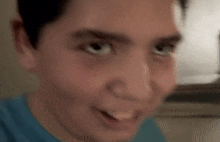 a close up of a man 's face with a blue shirt on making a funny face .
