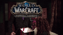 a world of warcraft battle for azeroth logo with a woman opening a gift